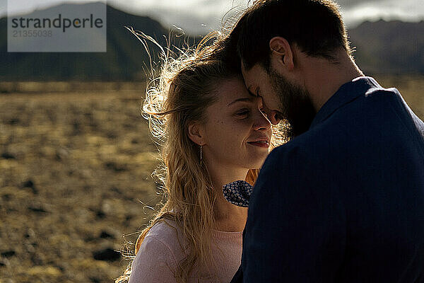 The groom kisses the bride in the mountains of Iceland.