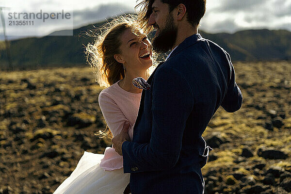 Couple in wedding suits in Iceland against the mountains