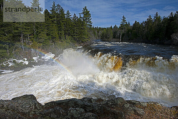 A rainbow forms over the spring runoff rushing over Grand Falls on the Dead River in western Maine.