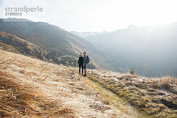 Hiking couple smiling on a scenic mountain trail in Tyrol  Austria