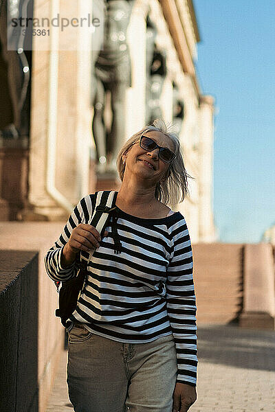 A middle-aged woman travels with a backpack