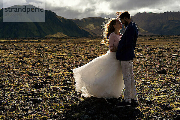 The groom kisses the bride in the mountains of Iceland.