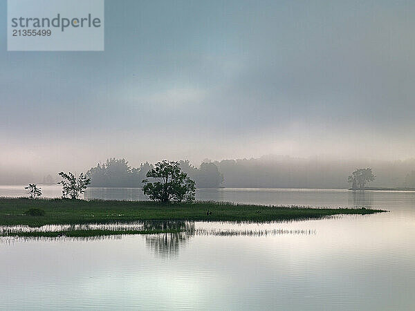 Early morning fog lifts off the still surface of Flagataff Lake near Stratton in Western Maine.