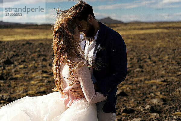 The groom kisses the bride in the mountains of Iceland.