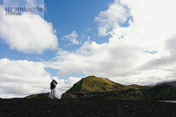 The groom kisses the bride in the mountains of Iceland