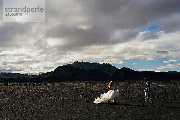 Couple in wedding suits in Iceland against the mountains