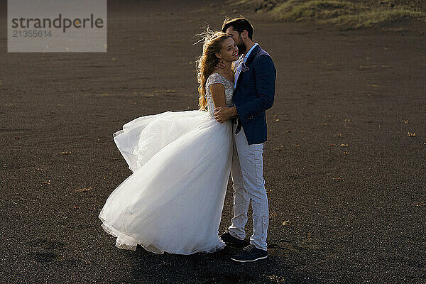 Couple in wedding suits in Iceland against the mountains