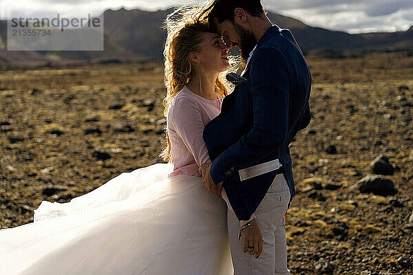 The groom kisses the bride in the mountains of Iceland.