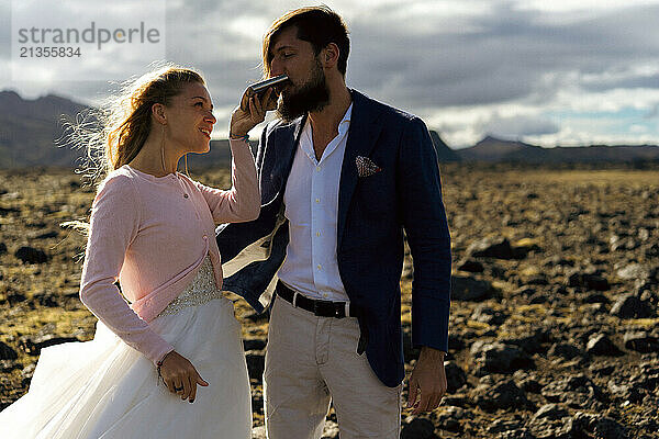 Couple in wedding suits in Iceland against the mountains