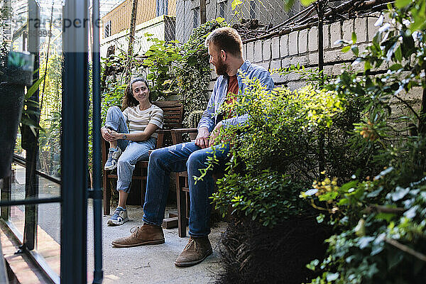 Multiracial couple sitting and discussing at garden centre