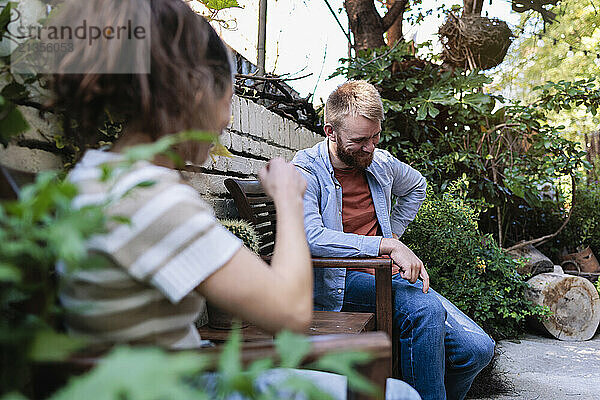 Man sitting and talking with girlfriend at garden centre