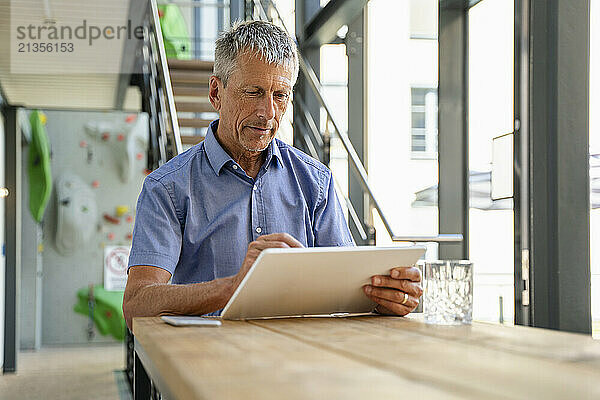 Businessman using tablet PC at table in office