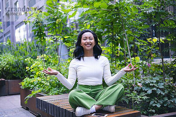 Smiling woman doing yoga at park