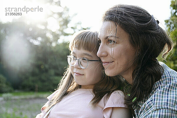 Affectionate mother spending leisure time with daughter wearing eyeglasses