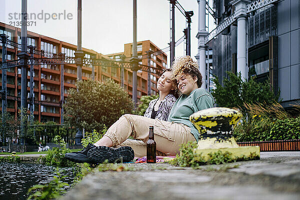 Happy lesbian couple sitting together in front of building