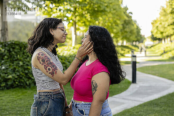 Romantic lesbian couple standing on footpath in garden