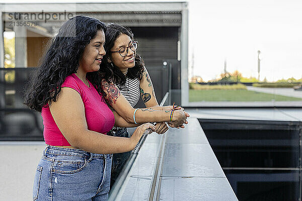 Happy gay couple spending leisure time with each other on bridge