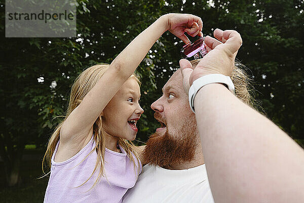 Playful father and daughter at park