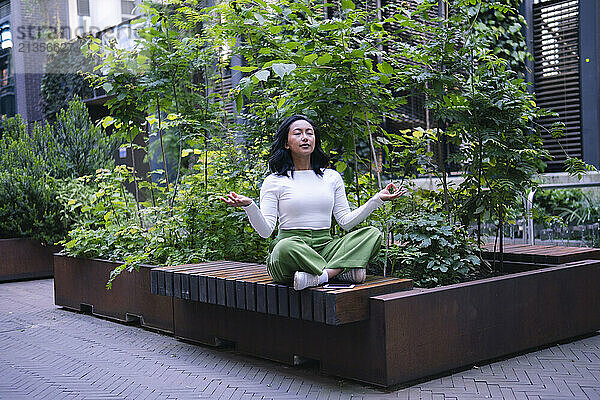 Woman with eyes closed practicing yoga at park