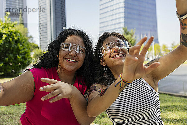 Happy lesbian couple wearing smart glasses at park