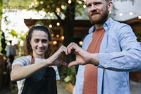 Multiracial couple making heart shape with hands