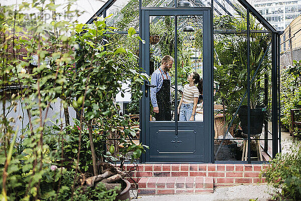 Couple standing and discussing in plant nursery