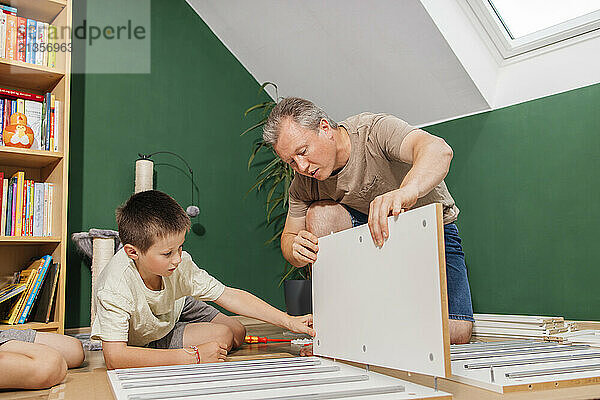 Father and son assembling new furniture at home