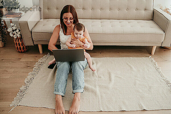 Smiling mother multi-tasking at home