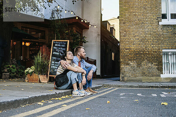 Couple spending leisure time sitting outside coffee shop