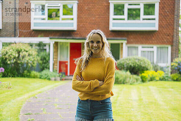 Smiling mature woman standing in front of building