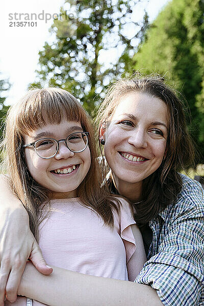 Happy mother embracing daughter wearing eyeglasses