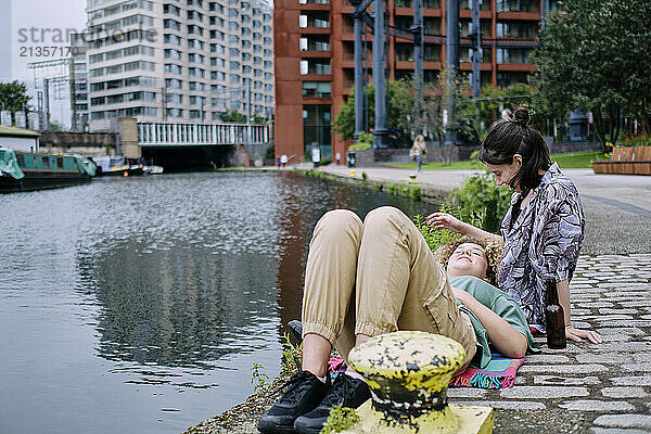 Happy lesbian couple relaxing near river in city