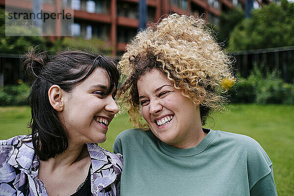 Happy young lesbian couple in front of building