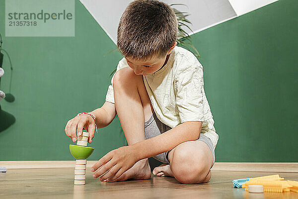 Boy playing with toys on floor at home