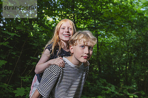 Boy carrying his younger sister on his back  Hamburg  Germany