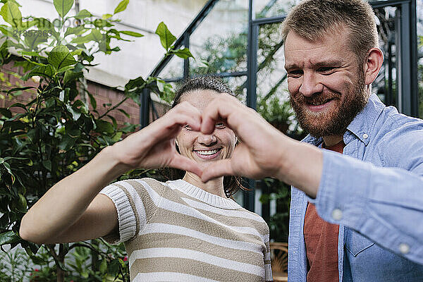 Happy couple making heart shape with hands