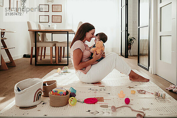 Mother spending leisure time playing with daughter in living room