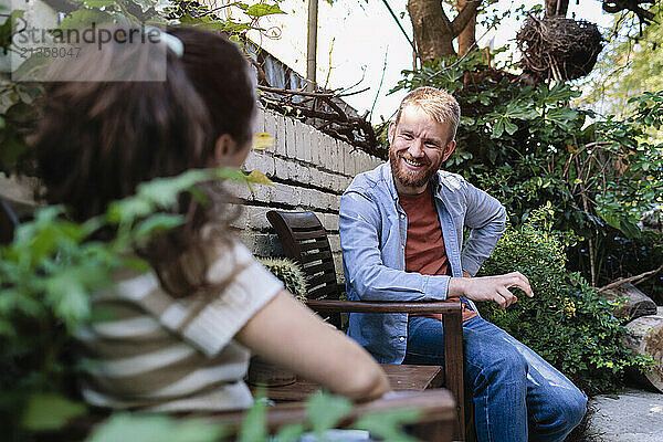 Happy man sitting and talking with girlfriend at garden centre