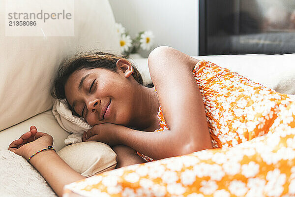 Innocent girl sleeping on bed at home