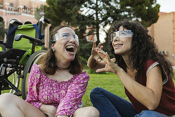 Assistant nurse wearing smart glasses and gesturing near woman with physical disability