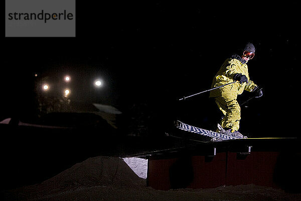 Young skier in jib park at night.