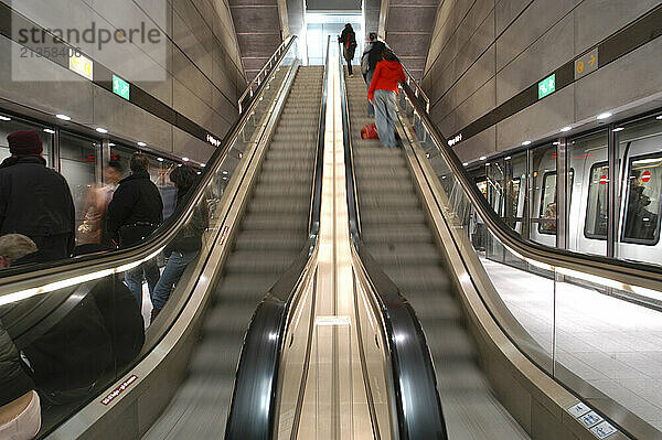 Commuters ride the escalator and board subway trains in Copenhagen  Denmark. Scandinavia.