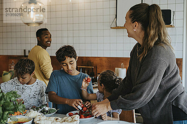 Multiracial family cooking food in kitchen at home