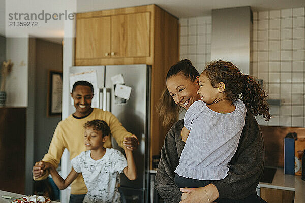 Happy multiracial family enjoying in kitchen at home