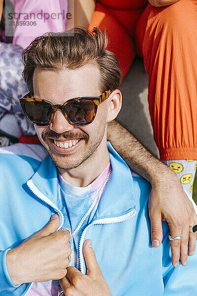 High angle view of smiling young man wearing sunglasses at sunny day