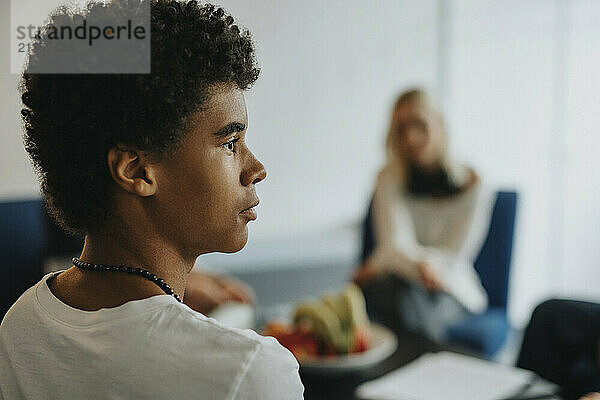 Teenage boy with curly hair at school