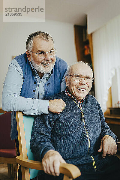 Happy senior male friends spending leisure time at retirement home