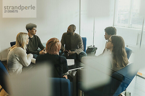 School counselor guiding male and female students during group therapy