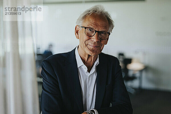 Portrait of smiling senior businessman wearing eyeglasses in office