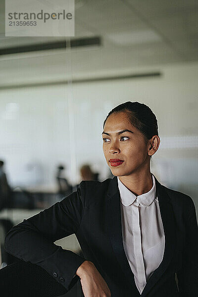 Thoughtful female business professional in suit at office